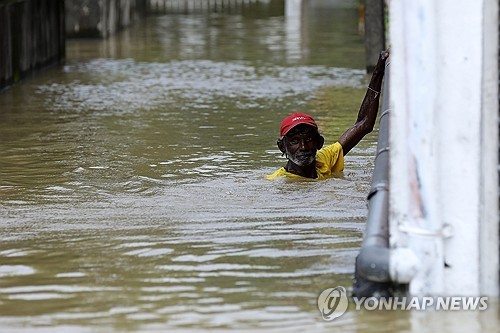 침수된 도로 건너는 스리랑카인