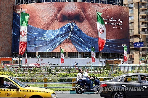 트럼프 대통령과 호르무즈 해협이 등장하는 그림이 걸려 있는 이란 테헤란 광장 